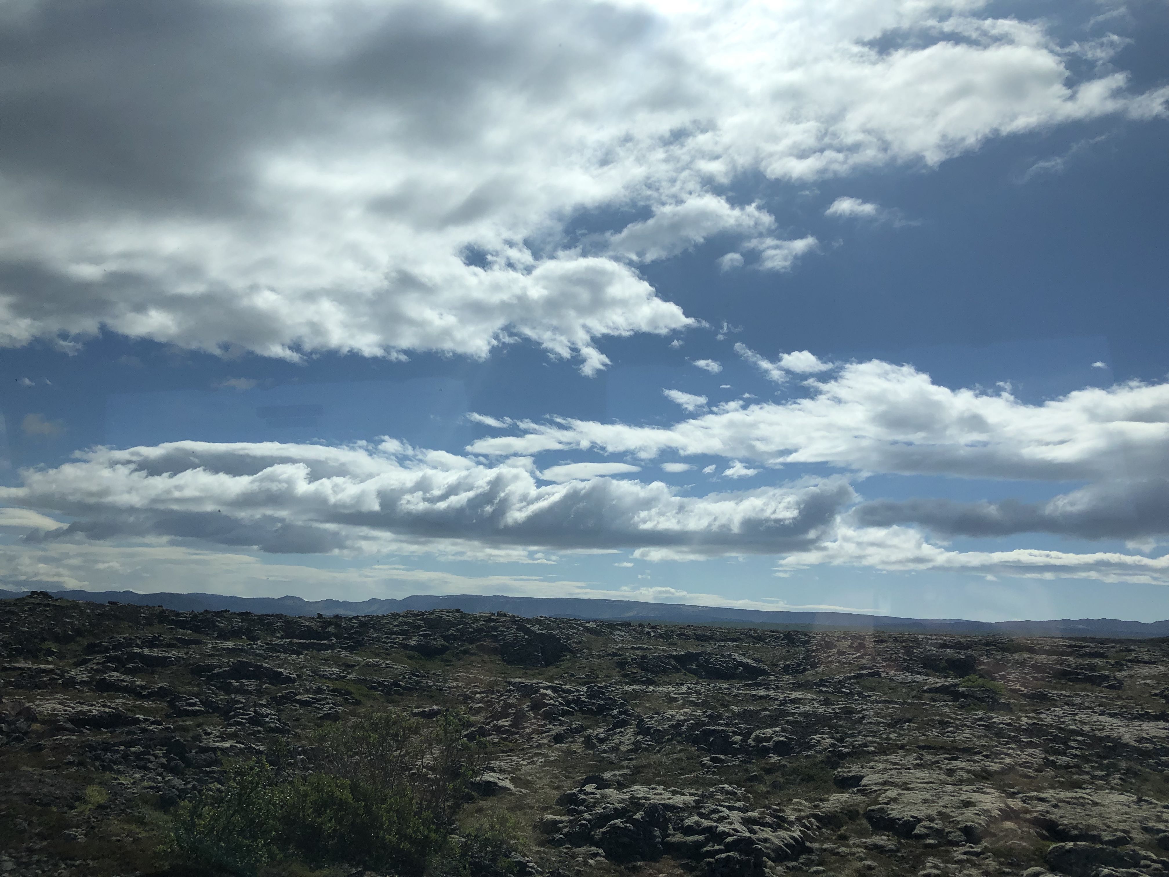 Image of Icelandic countryside on the route from the airport to Reykjavik. Rocky and blue skies