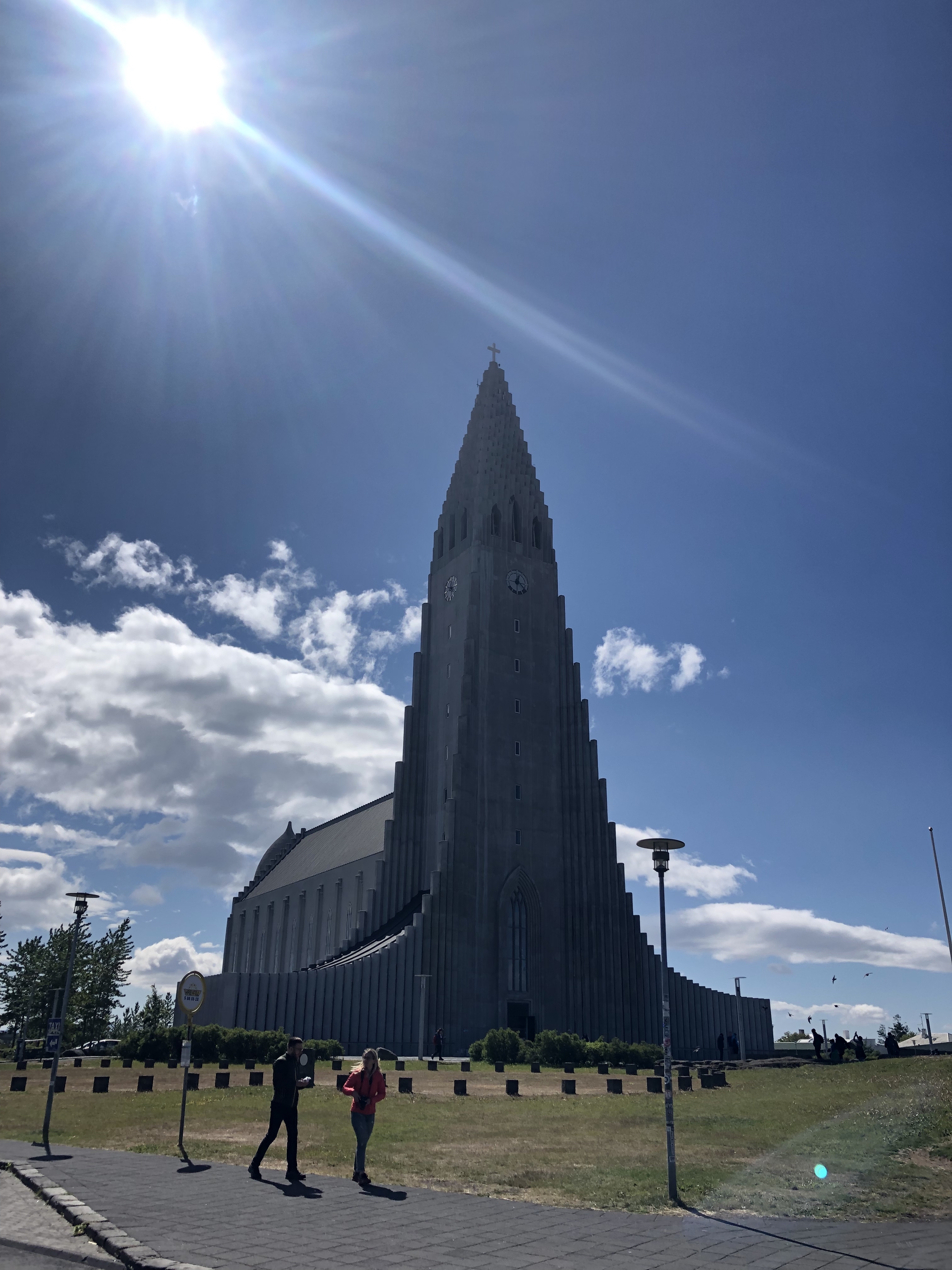 Large church in Iceland. Shaped like a rocket and pointing into a blue sky with a cross at the top