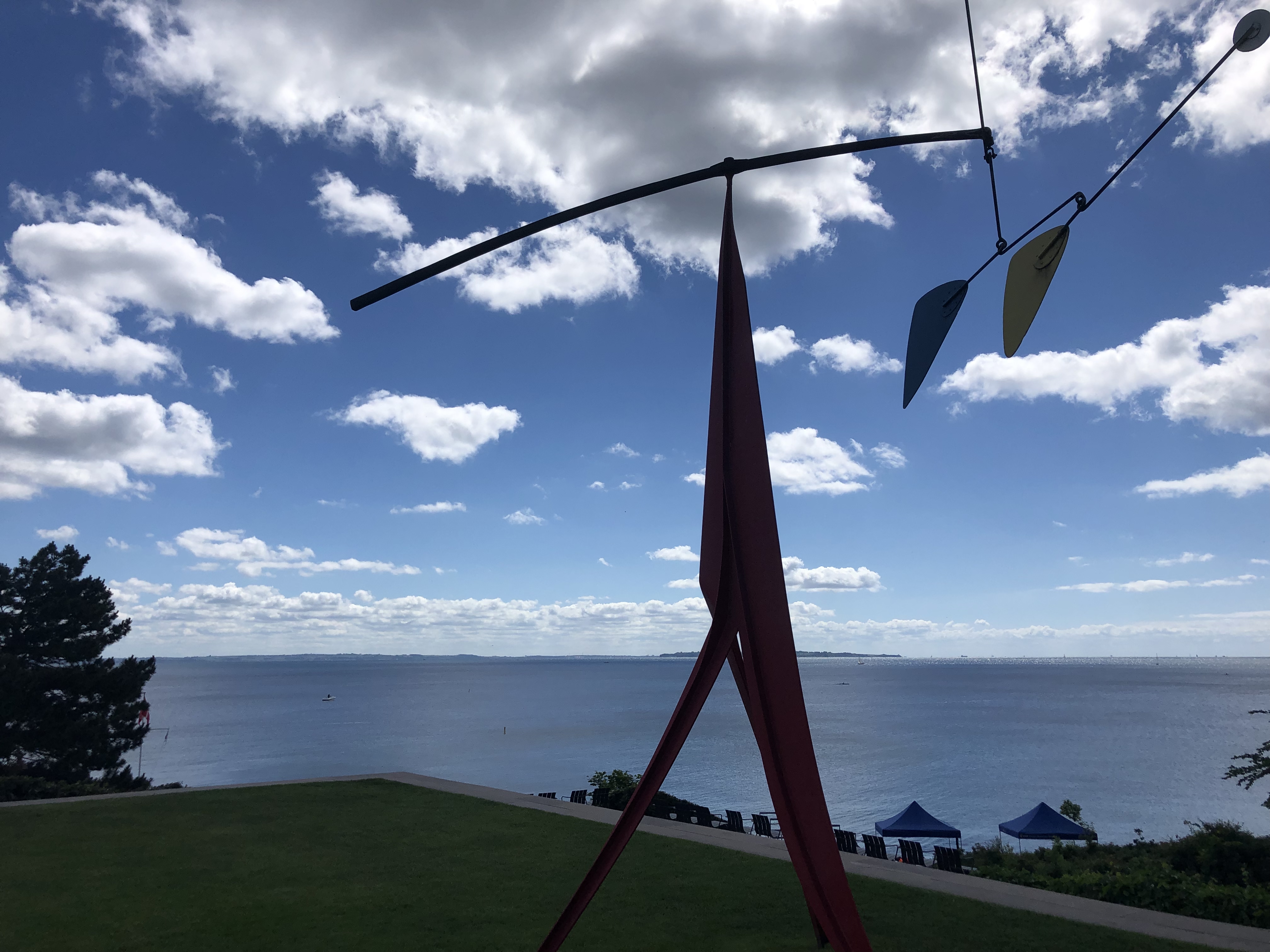 Alexander Calder mobile sculture in the Louisiana yard with the ocean and blue skies behind it.