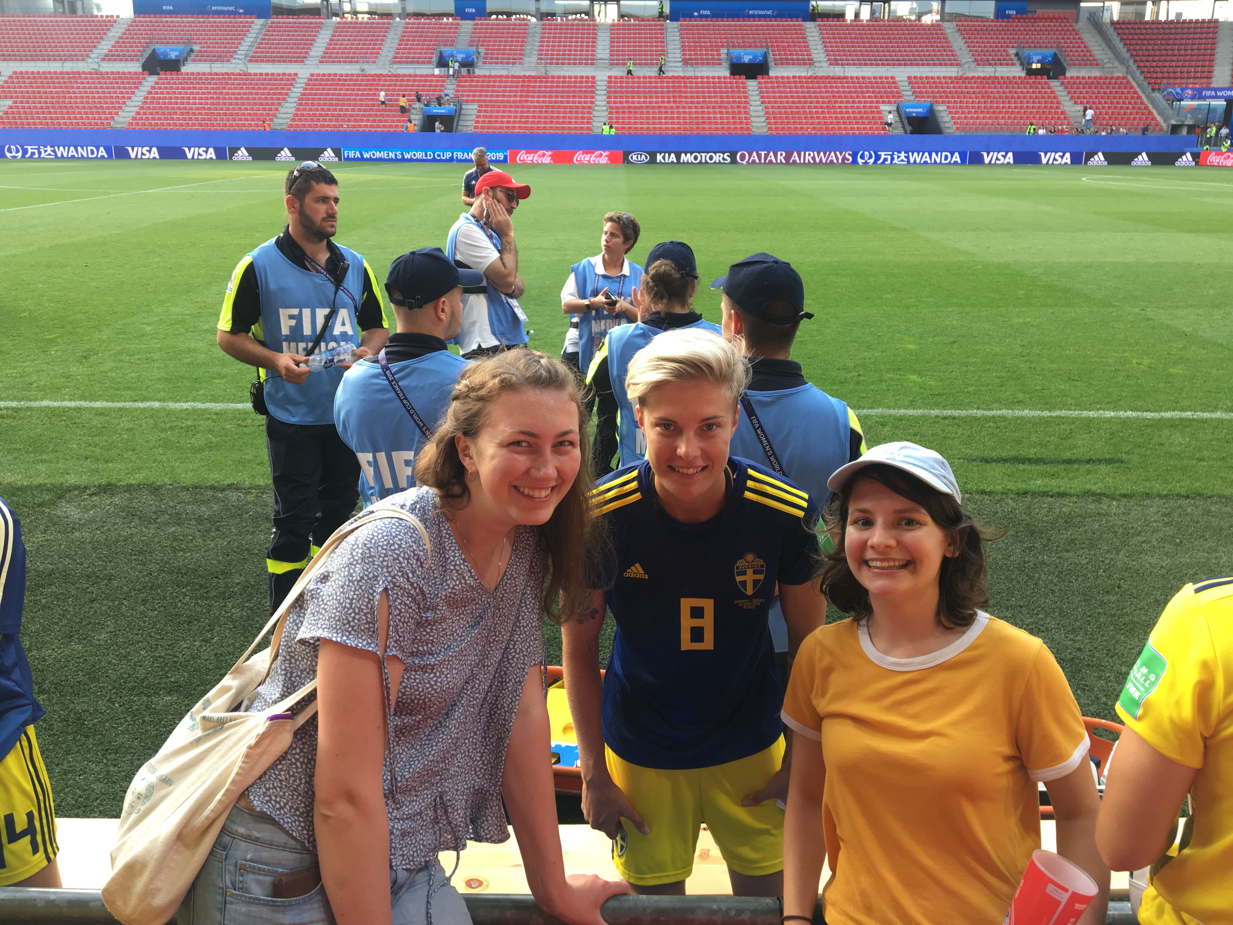 A Swedish soccer player and two fans next to the field