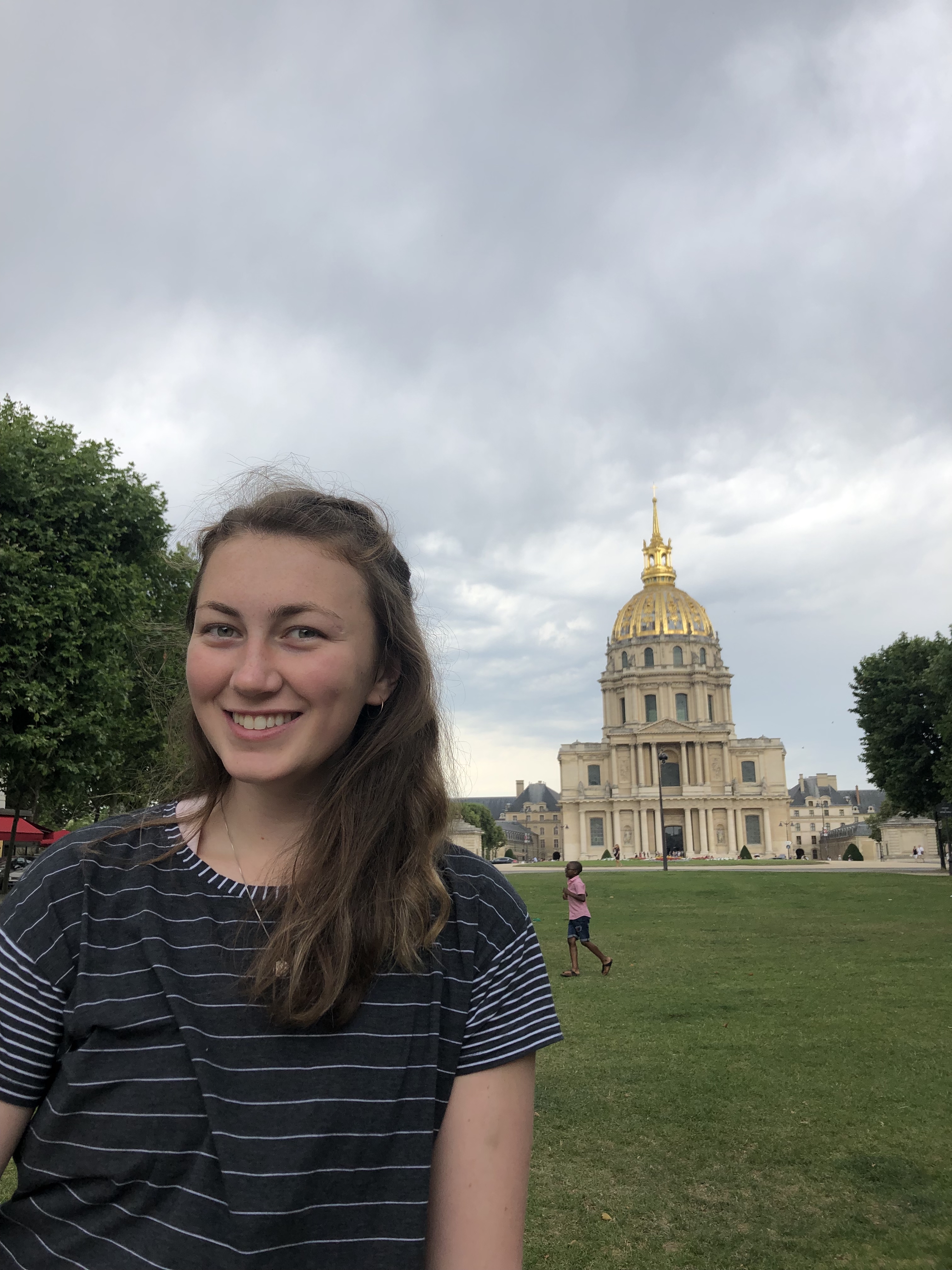 Girl next to building with gold dome in france