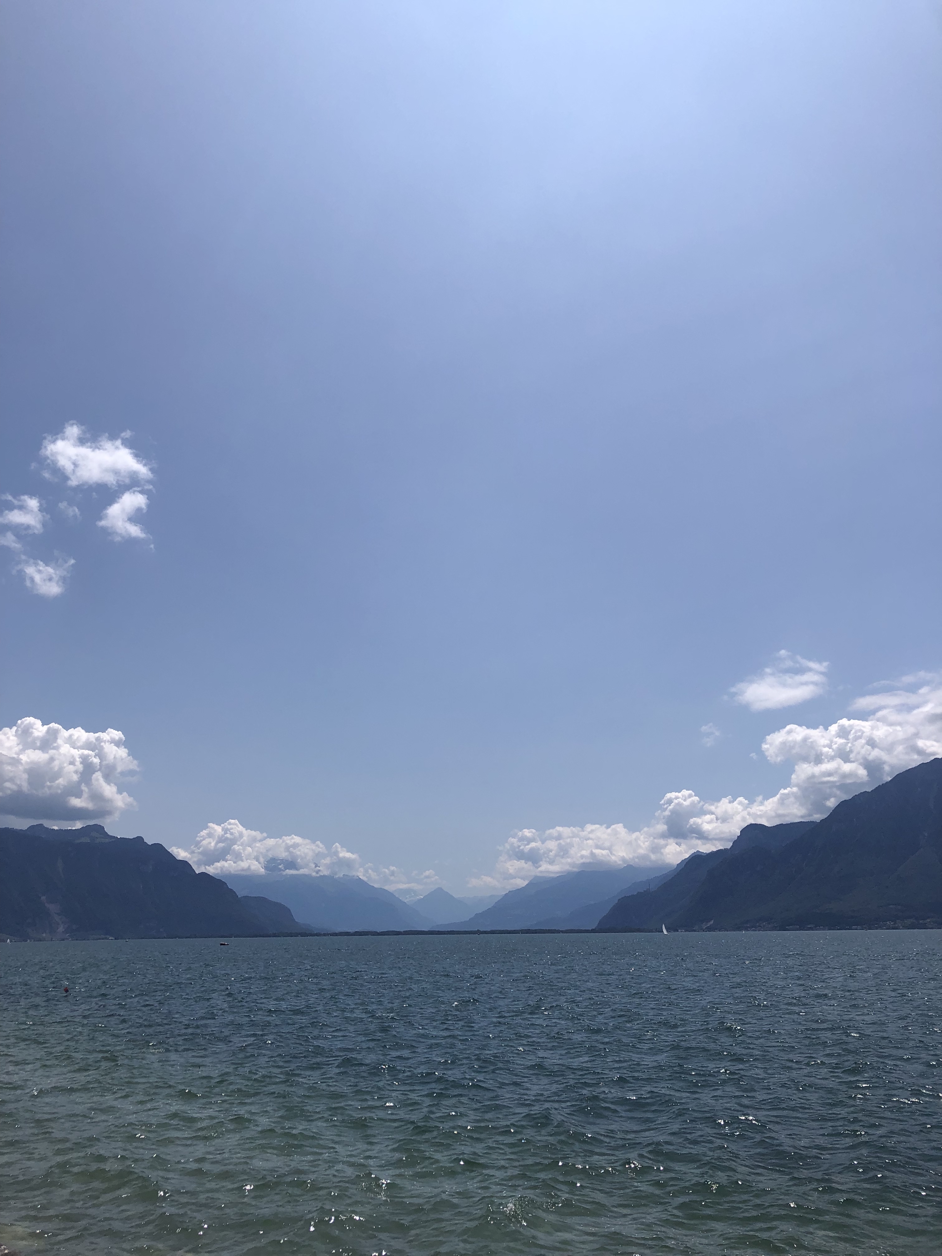 Lake Geneva with a blue sky and mountains